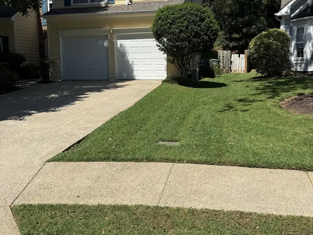 Mowed and edged front lawn beside a driveway and sidewalk in Cobb County, GA